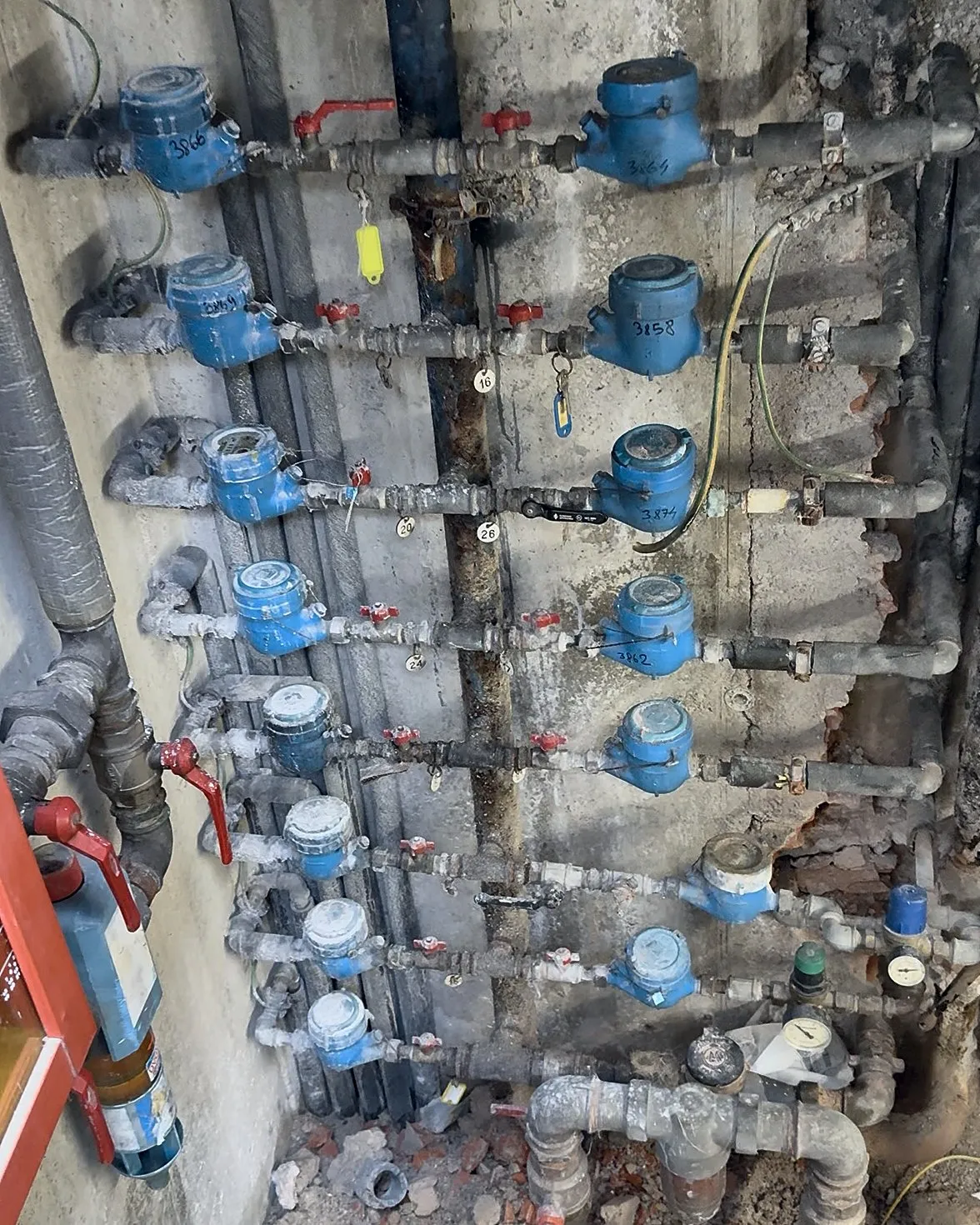 Batteria di contatori condominiali prima dell'intervento di rifacimento e riordino delle tubazioni.