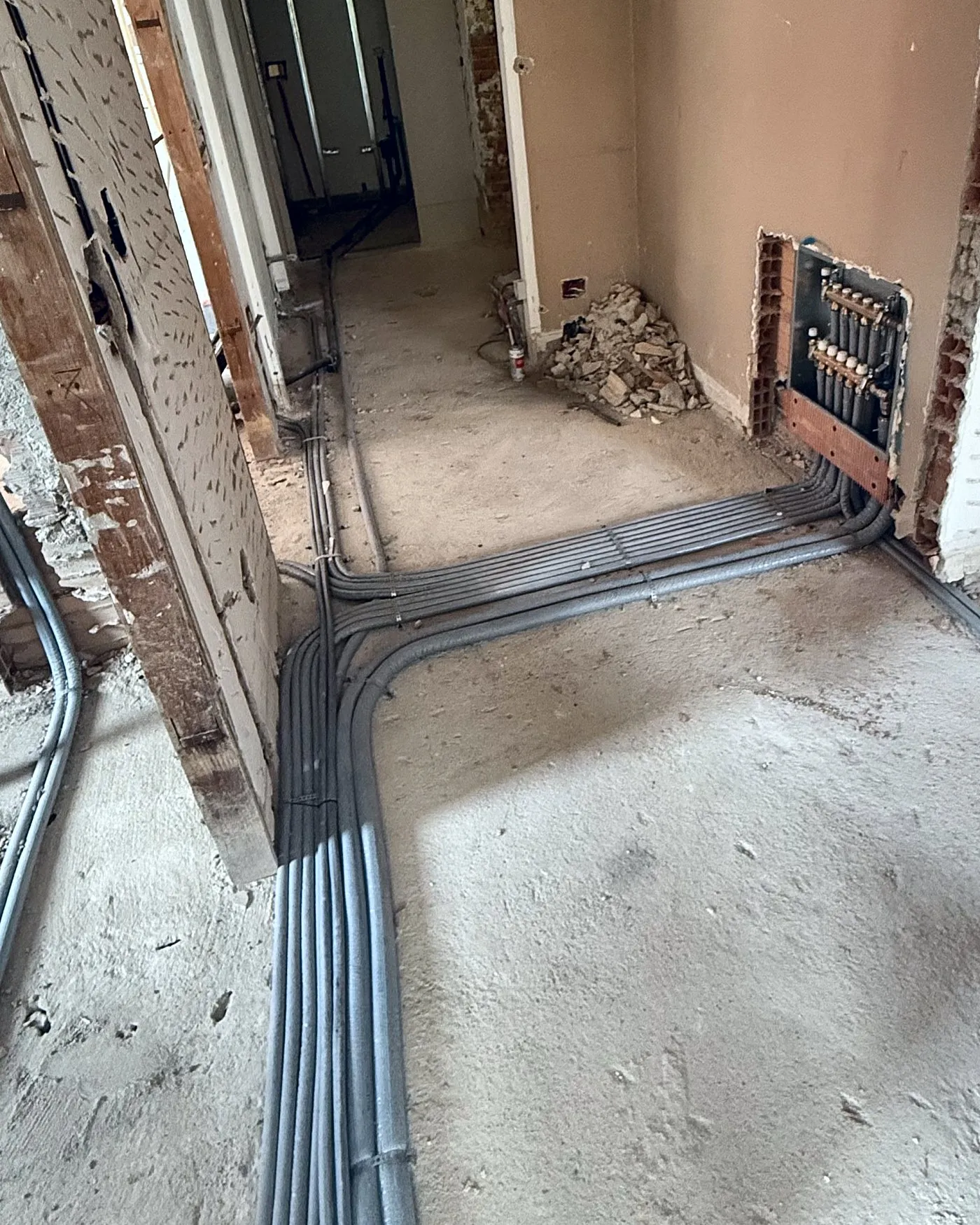 Cantiere di un appartamento: il fascio di tubazioni a pavimento percorre il corridoio fino alla cassetta del collettore
